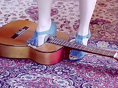 Girl crushing a guitar in high heels